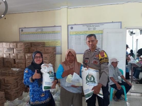Anggota Polsek Indramayu kawal penyaluran bantuan pangan di Desa Plumbon, Kecamatan Indramayu, Rabu (17/12/2025).