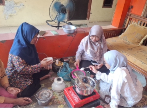 Ibu-ibu rumah tangga sedang menyaring minyak jelantah 